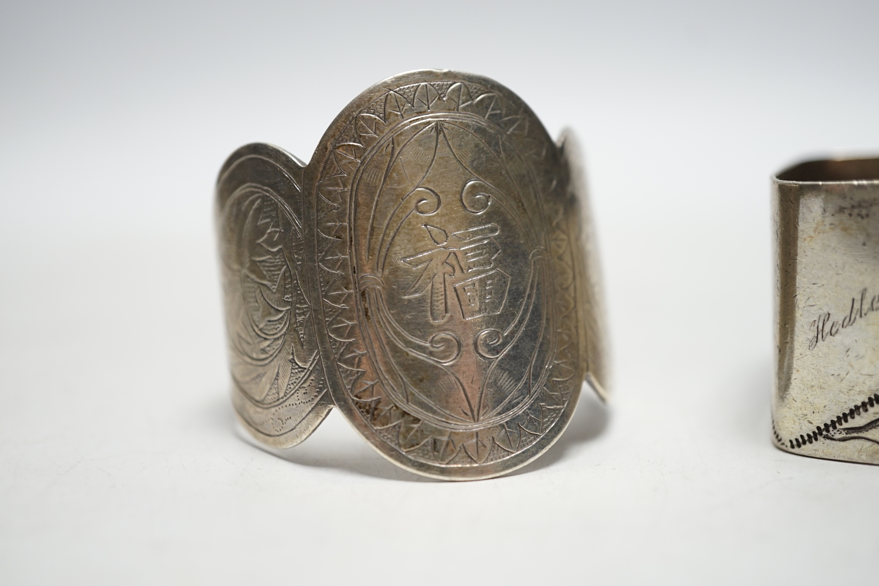 Two Chinese engraved white metal napkin rings.